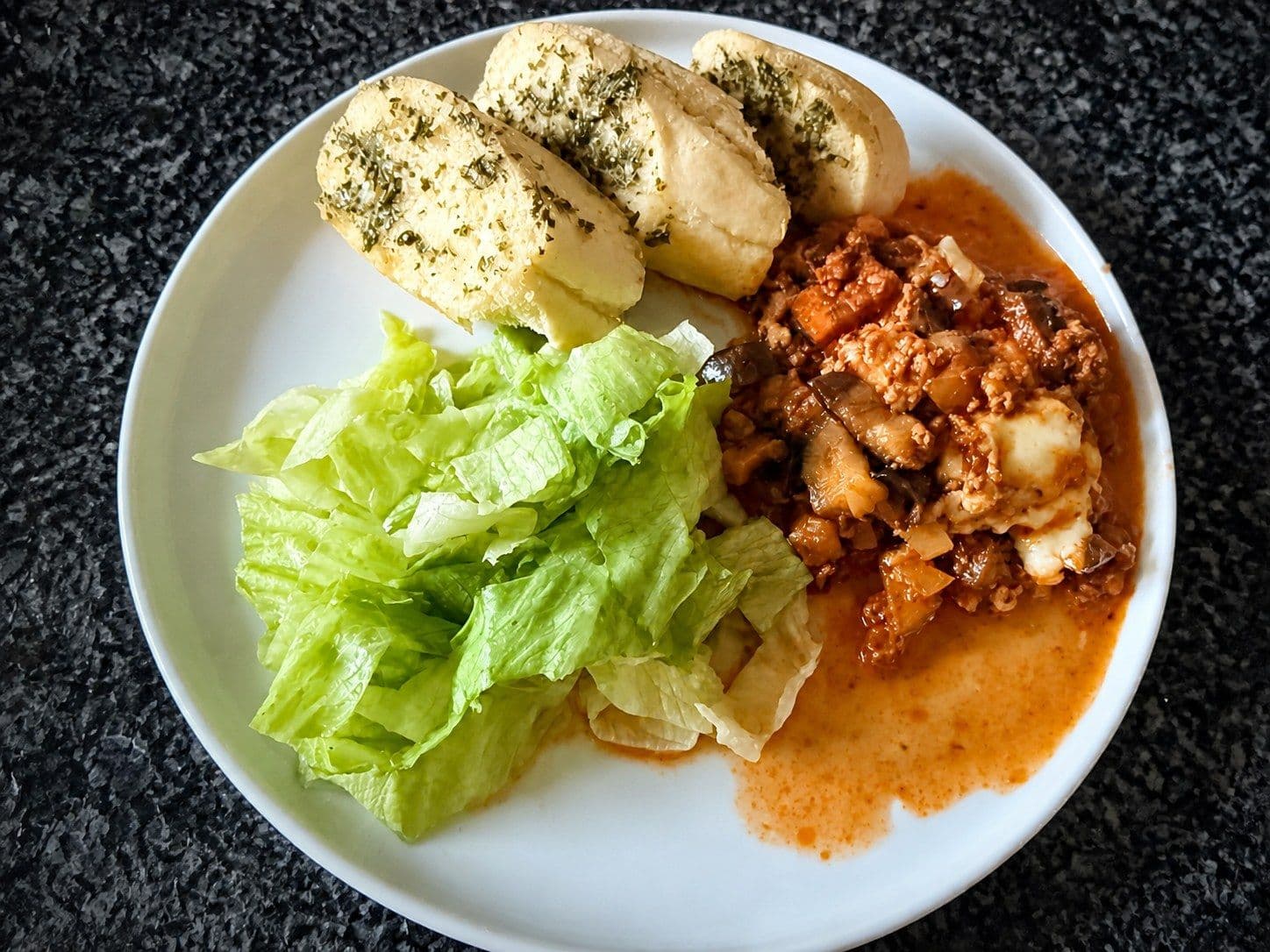 Überbackene Auberginen mit Rindshackfleisch, Tomatensauce und geschmolzenem Mozzarella.