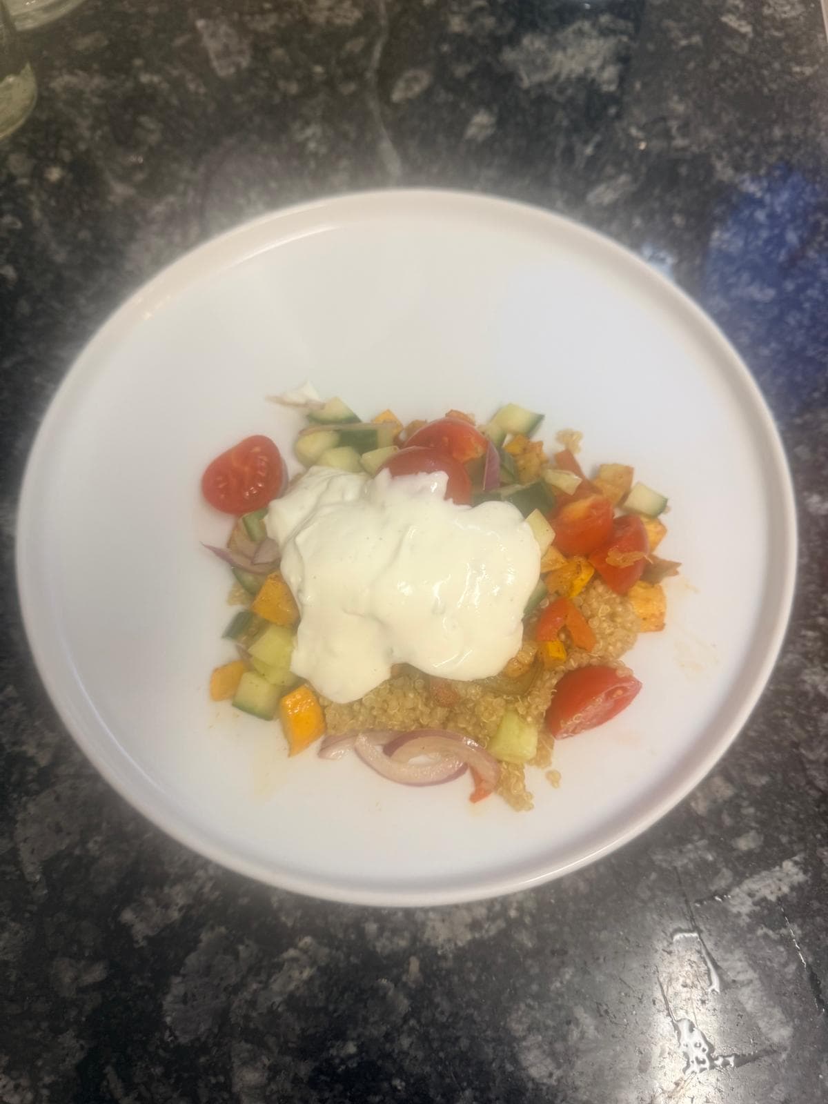 Sommerliche Quinoa-Bowl mit geröstetem Gemüse, Gurke, Cherr-Tomaten, roten Zwiebeln und Kräuter-Joghurt